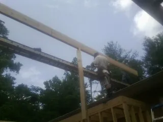 Carpenter setting a ridge beam over a new addition frame — Ice Dam Removal by Roofing Brothers in Deep Run