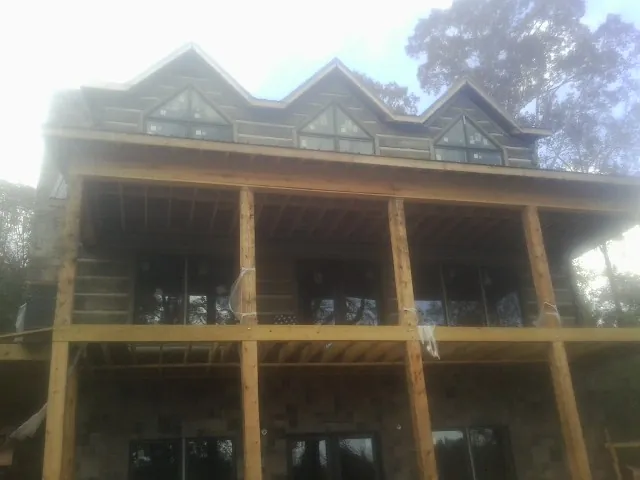 Dormers and porch framing on a large log home under construction — Roof Coating work by our crew in Deep Run